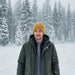 man in snow wearing mustard beanie